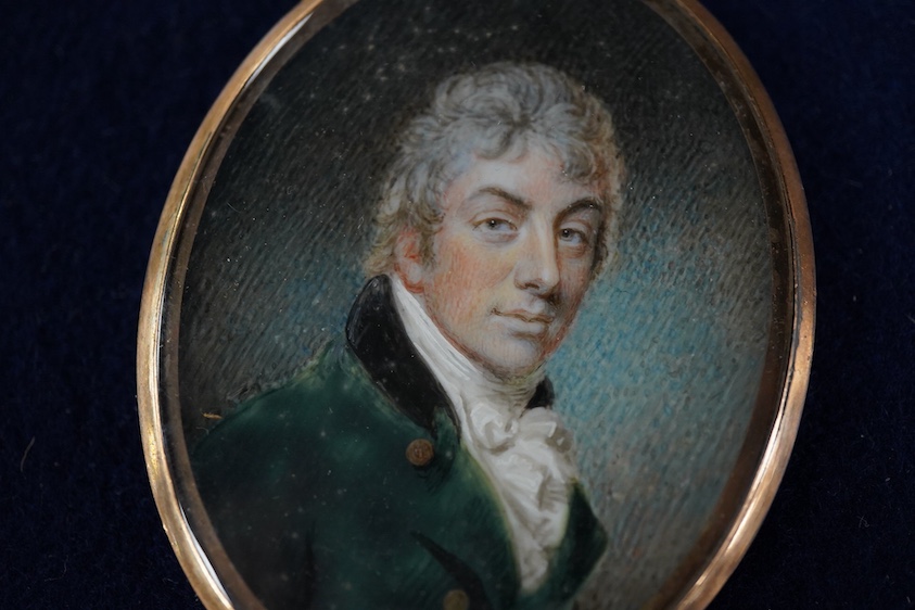 Regency School, Portrait miniature of a gentleman wearing a frock coat and cravat, oval watercolour on ivory, with hair-work panel verso, 6 x 4cm, housed in a gilt metal pendant frame CITES Submission reference 75C3EP3V
